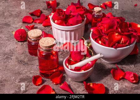Rosewater con petali di rosa. Fare essenza di rosa organica per cucinare Kerala India. Aromaterapia, relax spa, concetto cosmetico. Luce moderna, Foto Stock