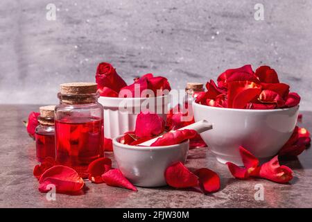 Rosewater con petali di rosa. Fare essenza di rosa organica per cucinare Kerala India. Aromaterapia, relax spa, concetto cosmetico. Luce moderna, Foto Stock