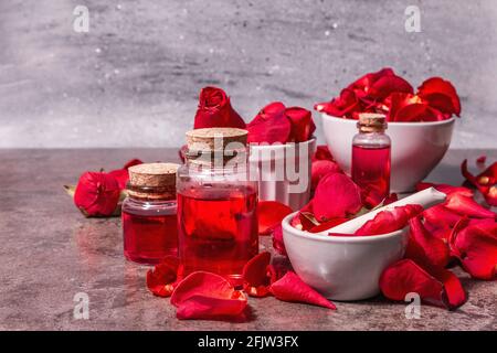 Rosewater con petali di rosa. Fare essenza di rosa organica per cucinare Kerala India. Aromaterapia, relax spa, concetto cosmetico. Luce moderna, Foto Stock