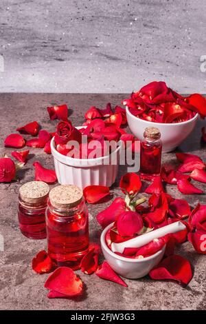 Rosewater con petali di rosa. Fare essenza di rosa organica per cucinare Kerala India. Aromaterapia, relax spa, concetto cosmetico. Luce moderna, Foto Stock