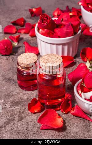 Rosewater con petali di rosa. Fare essenza di rosa organica per cucinare Kerala India. Aromaterapia, relax spa, concetto cosmetico. Luce moderna, Foto Stock