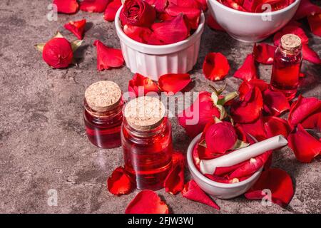 Rosewater con petali di rosa. Fare essenza di rosa organica per cucinare Kerala India. Aromaterapia, relax spa, concetto cosmetico. Luce moderna, Foto Stock