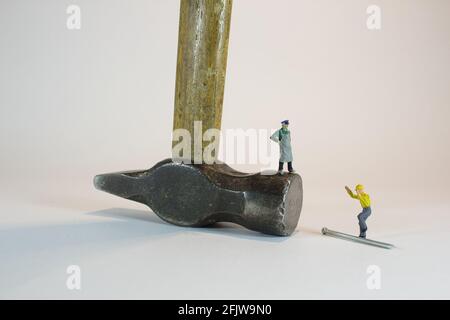Mini-figura di un uomo in piedi su una testa hummer capovolta e parlare con un'altra persona Foto Stock