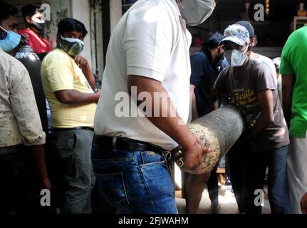 Nuova Delhi, India. 26 Apr 2021. Due uomini spostano una bombola di ossigeno medicale ricaricata per i pazienti COVID-19 di fronte a un negozio a Nuova Delhi, India, 26 aprile 2021. Credit: Parta Sarkar/Xinhua/Alamy Live News Foto Stock