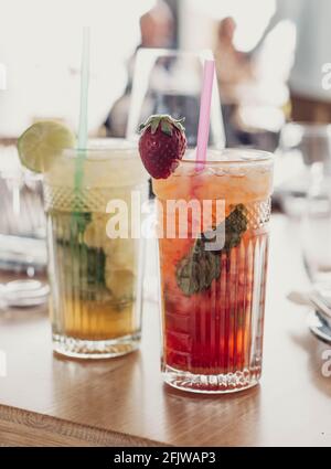 Due cocktail mojito preparati con rum invecchiato, menta e frutta diversa. Una fragola e l'altra frutto della passione Foto Stock