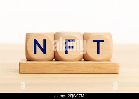 Testo NFT su blocchi di legno. Gettone non fungibile. Spazio di copia. Sfondo bianco Foto Stock