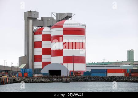Taniche e hangar bianchi rossi. Edifici portuali dell'Islanda Foto Stock