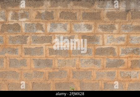 Struttura di una parete ruvida fatta di pietre di cemento con mortaio fresco Foto Stock