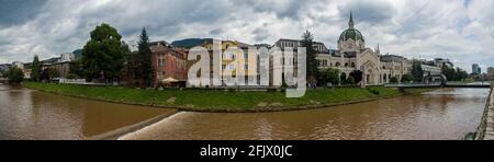 Vista panoramica sul fiume Miljacka, l'Accademia di Belle Arti è l'edificio e il ponte di Festina lente. Sarajevo. Bosnia-Erzegovina Foto Stock