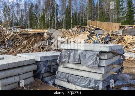 Rifiuti di costruzione e rifiuti. Lastre di cemento armato. Rifiuti di costruzione scarico in natura. Foto Stock