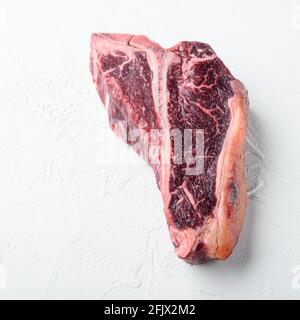 Italian Florentine T Bone Dry Aged Beef Steak Set, su fondo di pietra bianca, formato quadrato Foto Stock