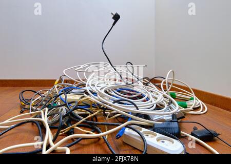 Un groviglio di fili non necessari si trova sul pavimento. Foto Stock