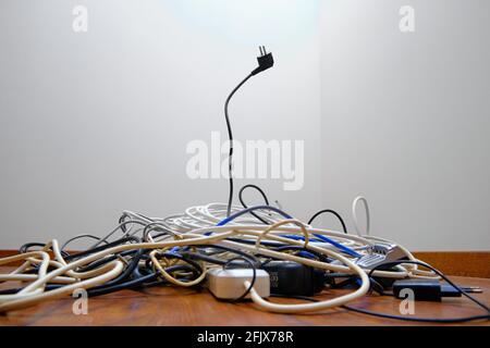 Un groviglio di fili non necessari si trova sul pavimento. Foto Stock