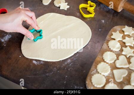 Ritratto giovane adulto brunette caucasica donna che fa l'impasto con rullo spilla per dolci gustosi biscotti fatti in casa in cucina. Donna casalinga Foto Stock