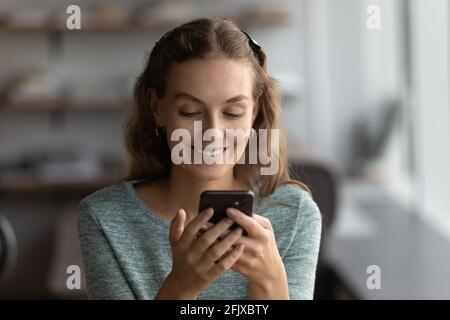 Felice giovane donna parlare in videochiamata sul cellulare Foto Stock