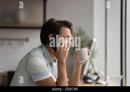 Uomo caucasico bere caffè parlare su smartphone Foto Stock