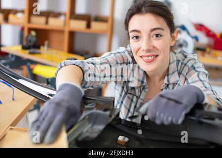 Mechanic esaminando sotto il cofano di auto presso il garage di riparazione Foto Stock