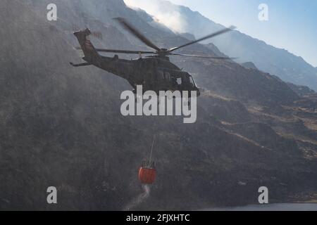 Killarney National Park, Irlanda - 26 aprile. 2021: Elicottero Irish Air Corp che raccoglie acqua per spegnere il fuoco nel parco nazionale di Killarney Foto Stock