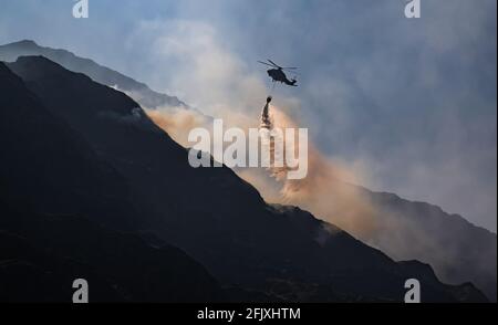 Killarney National Park, Irlanda - 26 aprile. 2021: L'elicottero Irish Air Corp scarica l'acqua per spegnere il fuoco nel parco nazionale di Killarney Foto Stock