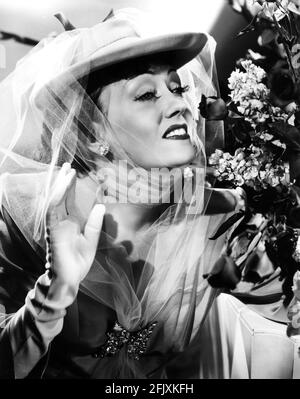 1951 , USA : l'attrice GLORIA SWANSON ( 1898 - 1983 ) al momento del rilascio del film SUNSET BOULEVARD ( Viale del Tramonto ) di Billy Wilder, Paramount publicity Still - FILM - CINEMA - attrice cinematografia - cappello - veletta - velo - cappello - DIVA - DIVINA - DIVINA - DIVINA - spilla a forma di farvalla - farfalla pin - gioielli - gioiello - gioiello - gioielli - gioielli - bijoux - bigiotteria - guanti bianchi - guanti lunghi bianchi - mazzo di fiori - fiori ---- Archivio GBB Foto Stock