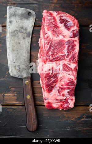 Scotch Filet intero taglio, costolette di manzo marmorizzato occhio scelta top carne set, con vecchio coltello sfaldatore macellaio, su vecchio tavolo di legno scuro sfondo, vista dall'alto piatto Foto Stock