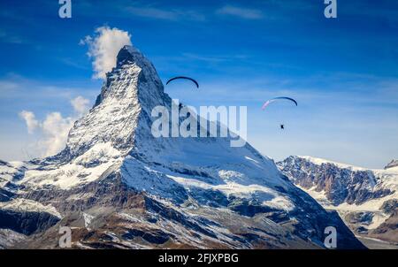 Due parapendio sulle Alpi svizzere con il Cervino sullo sfondo Foto Stock