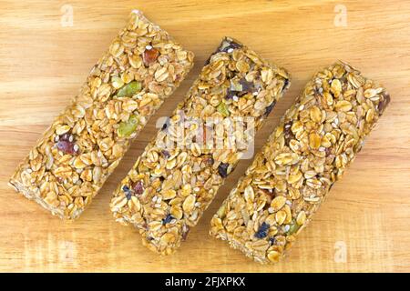 Barretta di muesli di frutta e noci, snack sano con fonte di fibra, alto in grano intero, nessun colore artificiale o sapore, su fondo di legno Foto Stock