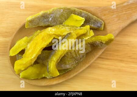 Fette di guava secca, snack sano conservato su cucchiaio di legno, vista dall'alto sul pavimento in legno Foto Stock