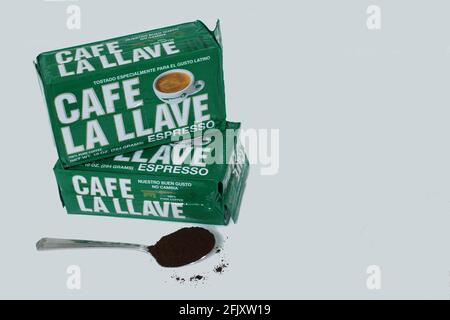 Caffè cubano la Llave in scatole e un cucchiaio pieno di caffè in polvere su sfondo bianco con copia spazio Foto Stock