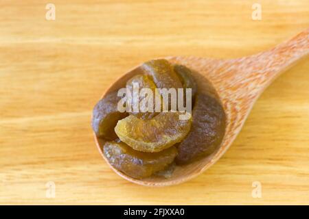 Frutta secca amla di frutti di bosco indiani in cucchiaino di legno Sfondo (Phyllanthus emblica) Foto Stock