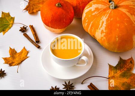 Frullato di zucca, latte speziato. Cocktail boozy con stecche di cannella stelle di anice. Decorazioni in foglie d'acero. Bevande calde stagionali autunnali. Giorno di ringraziamento Foto Stock