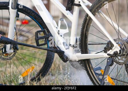 Lavaggio della molla della bicicletta sul cortile. Preparazione della molla per la stagione ciclistica. Fai-da-te cura delle biciclette, lavaggio a pressione delle biciclette Foto Stock