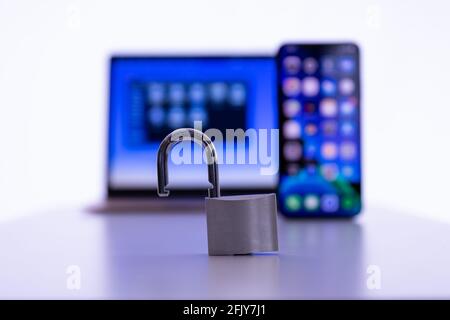 Privacy e protezione dei dati: Computer portatile e smartphone con lucchetto in primo piano Foto Stock