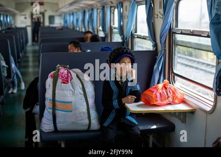 Chengdu, Xichang nella provincia sudoccidentale del Sichuan. 12 Aprile 2021. Layi Axia, una donna di 5634 anni del gruppo etnico Yi, prende il treno 75 a casa con rifornimenti di scorte di negozi acquistati da un mercato all'ingrosso a Xichang nella provincia sudoccidentale del Sichuan, il 12 aprile 2021. PER ANDARE CON XINHUA HEALDINES DEL 27 APRILE 2021 Credit: Shen Bohan/Xinhua/Alamy Live News Foto Stock