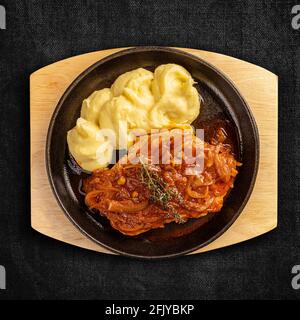 Piatto di costolette di maiale arrostite con stufato di cipolla servito con purè di patate Foto Stock