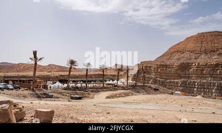 il campeggio deluxe glamping è in costruzione in un vecchio Cava di gesso nel cratere Makhtesh Ramon in Israele con palme e cielo Foto Stock