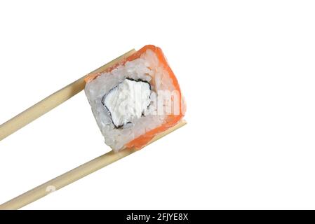 I chopsticks tengono il rotolo di sushi con il salmone Foto Stock