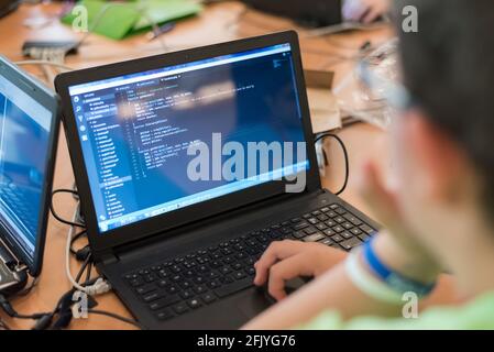 Programmazione di un giovane uomo su un computer portatile Foto Stock