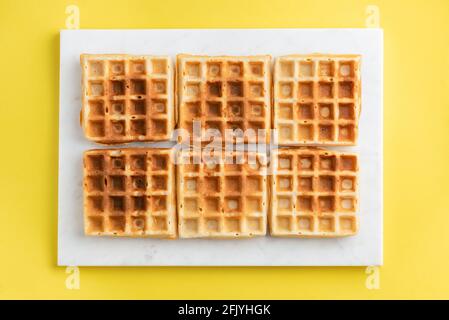 Cialde belghe su sfondo giallo texture di diversi belgi waffle Foto Stock