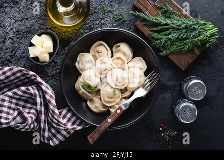 Gnocchi ripieni di carne, pelmeni russo con aneto in una ciotola, vista dall'alto Foto Stock