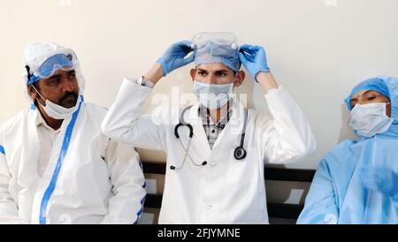 Gruppo di medici in protezione uniforme riposo e preparazione medica per continuare a lavorare Foto Stock