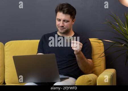 guy effettua acquisti o pagamenti online, guarda il codice di sicurezza cvv della carta di credito Foto Stock