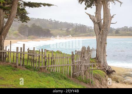 CARMEL, CALIFORNIA, STATI UNITI - Mar 09, 2021: Un'umile recinzione in legno indica il confine di Monastery Beach e la proprietà della Bay School in California Foto Stock