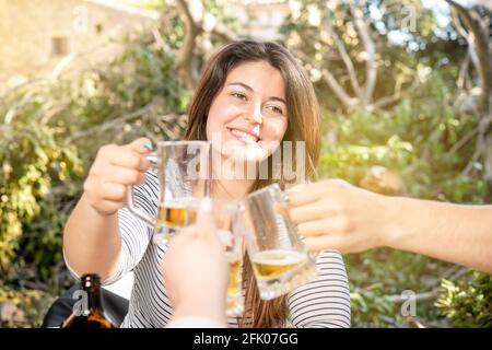 gruppo di persone che tostano con birra all'aperto Foto Stock