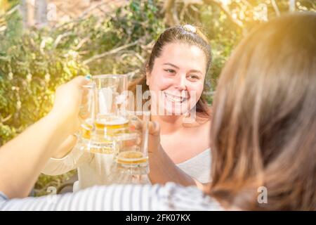 Felice giovane sorridente caucasica. I migliori amici bevono birra e tostano. Festa all'aperto felice Foto Stock