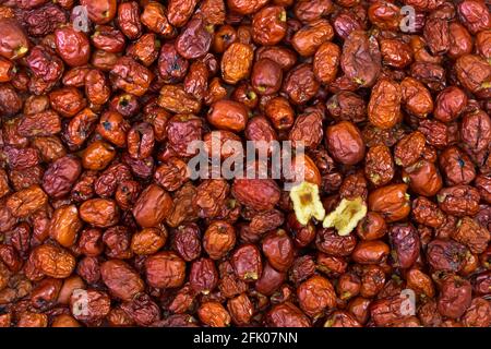 Closeup di done cinese snocciolato essiccato, chiamato anche Jujube, data rossa con un taglio a metà che mostra la consistenza interna (Ziziphus jujuba) Foto Stock