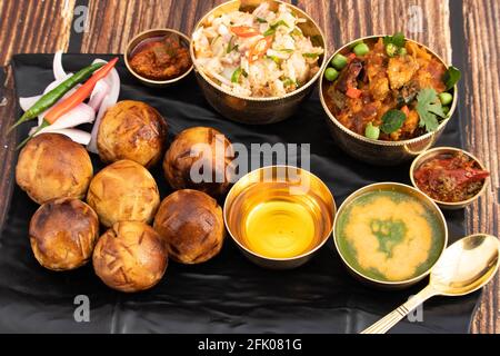 Litti Chokha o Liti Choka ripieni con Chana Sattu e. Drenched in Desi ghee è cibo regionale di Bihar Jharkhand E Uttar Pradesh è servito con Alo Foto Stock