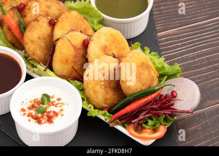 Delicious Indian Street Food Alo Tikki conosciuto anche come Alu Ki Tikkia UN condimento bollito purè di patata o frittatine Servito con Dhaniya Pudina Green Foto Stock