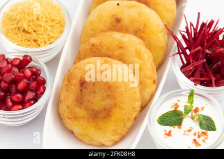 Delicious Indian Street Food Alo Tikki conosciuto anche come Alu Ki Tikkia è condito bollito purè di patate Cutlet o pattuglie Servito con Dahi Chat Masala An Foto Stock