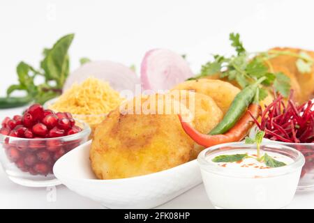 Alo Tikki, conosciuto anche come Alu Ki Tikkia, è condito Frittatine o frittatine di patate bollite usate in vari indiani Cibo di strada Masala Chaat spuntini Foto Stock